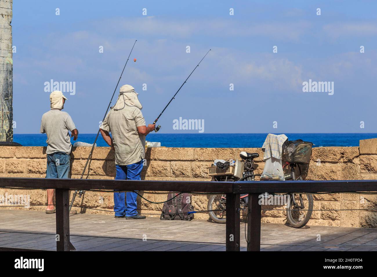 TEL AVIV, ISRAEL - SEPTEMBER 17, 2017: Unidentified fishermen catch fish on the embankment of old town Jaffa. Stock Photo