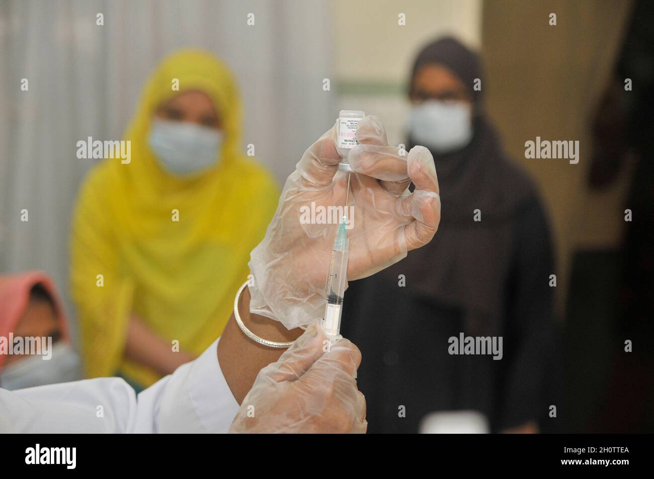 Sylhet, Bangladesh. 14th Oct, 2021. People stand in a long queue to receive the Pfizer-BioNTech Covid-19 Vaccine at the M A G Osmani medical college & hospital vaccination center. Credit: Majority World CIC/Alamy Live News Stock Photo
