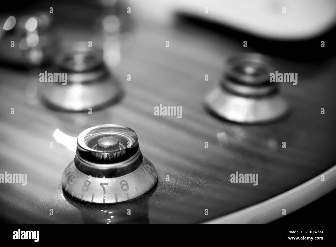Extreme close up of an electric guitar volume knob in black and white