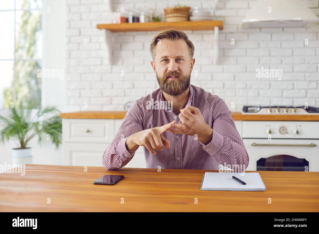 Businessman bends his fingers giving arguments to his client during video conversation. Stock Photo