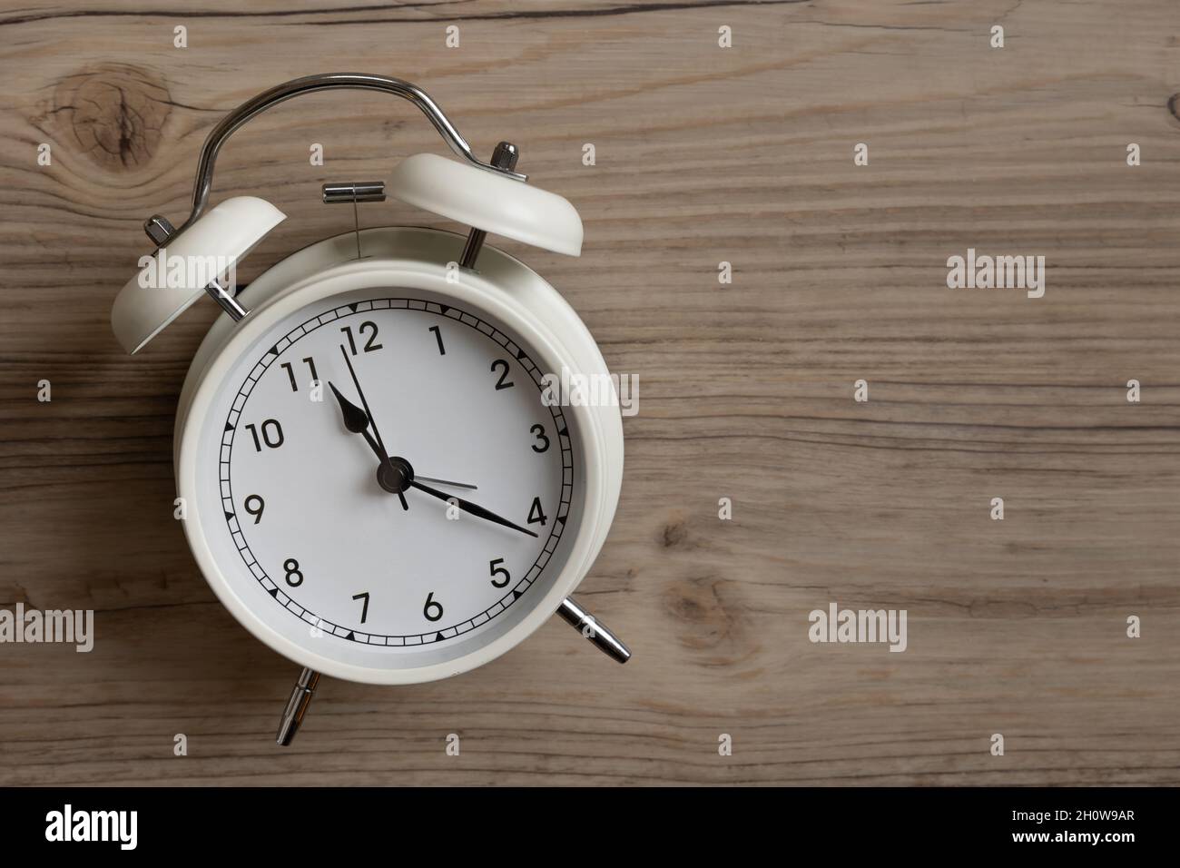 small white retro alarm clock on wood background with copy space Stock ...