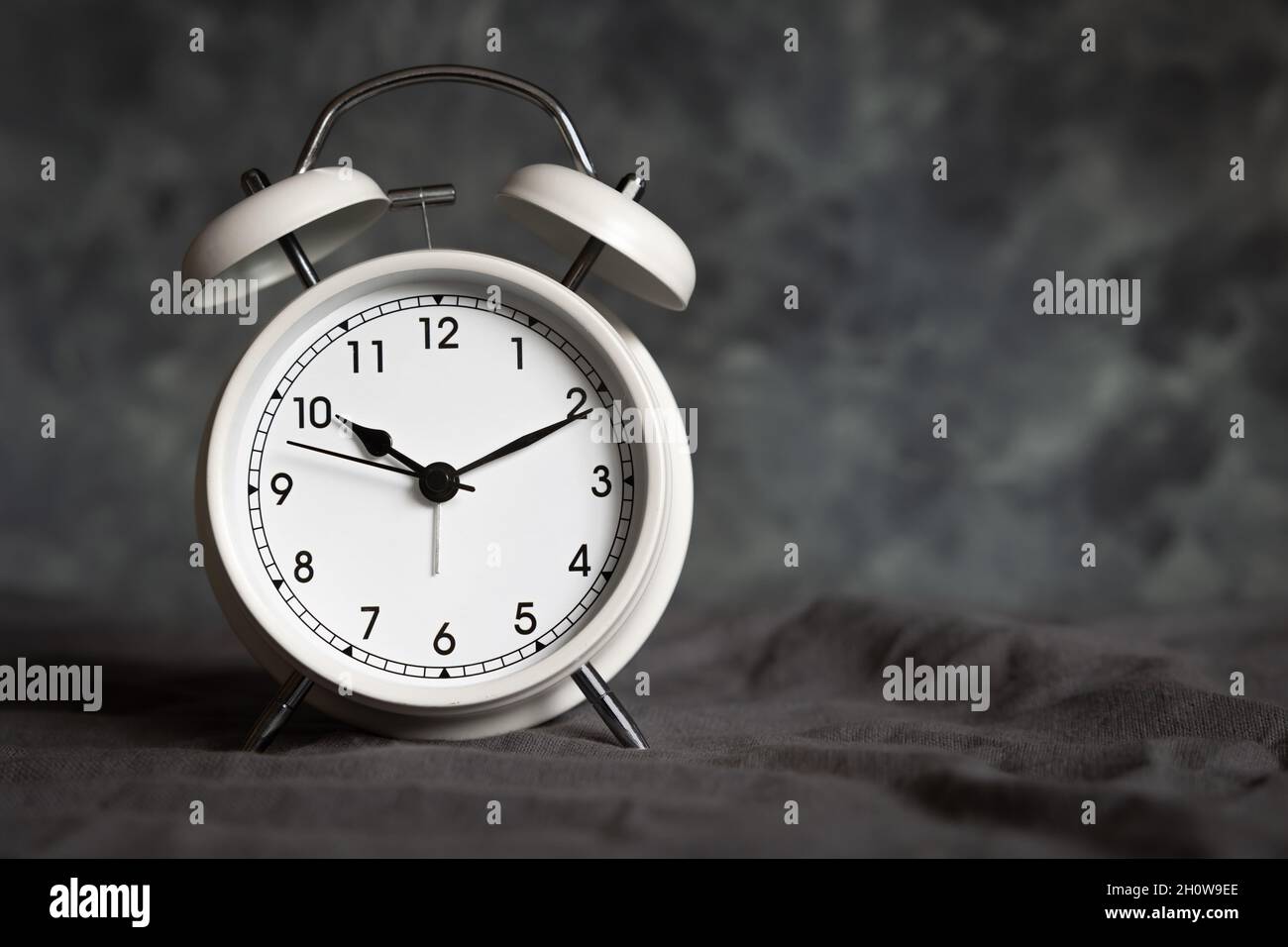small white retro alarm clock on a grey background with copy space Stock Photo