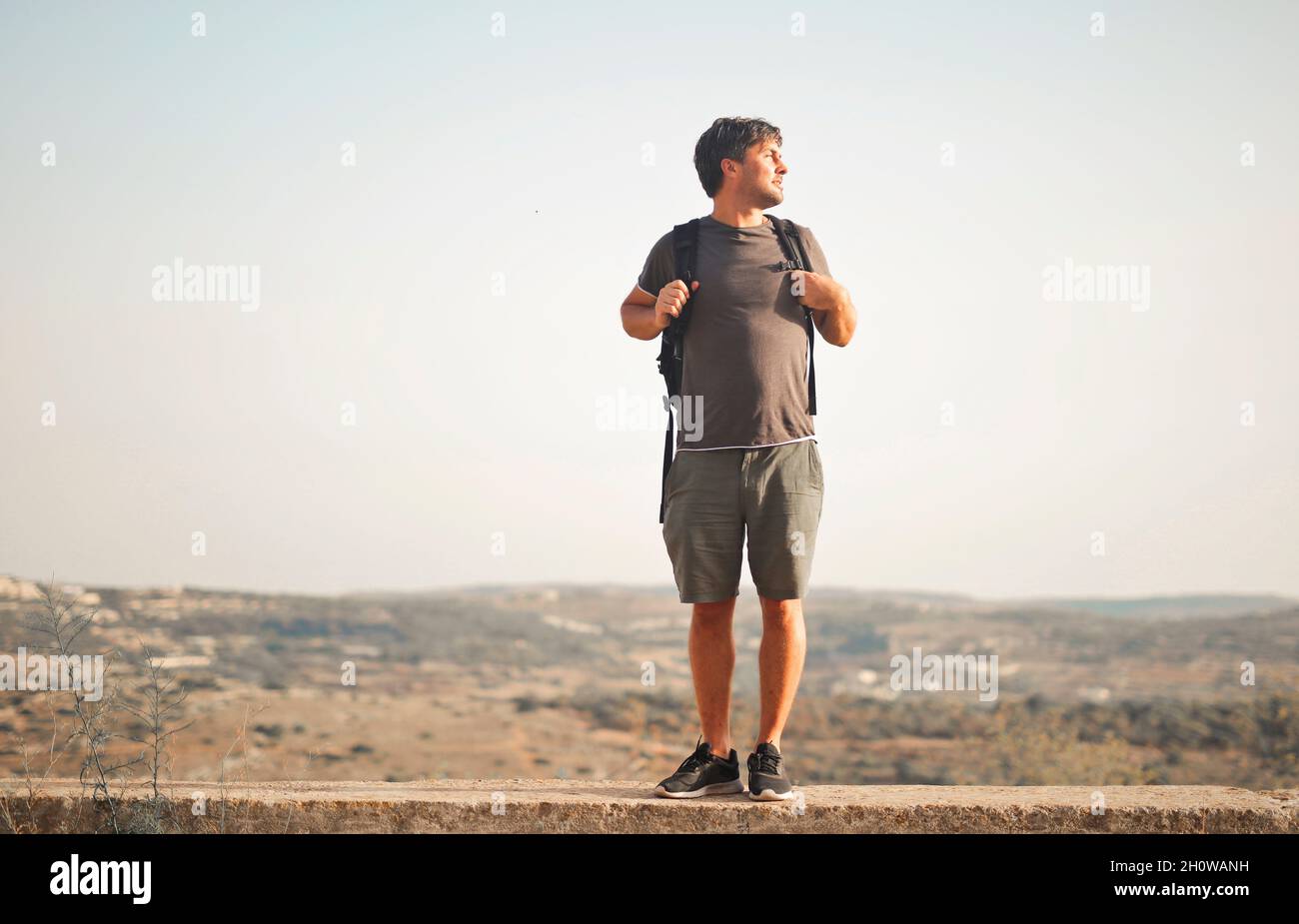 young man with backpacker looks at panorama Stock Photo