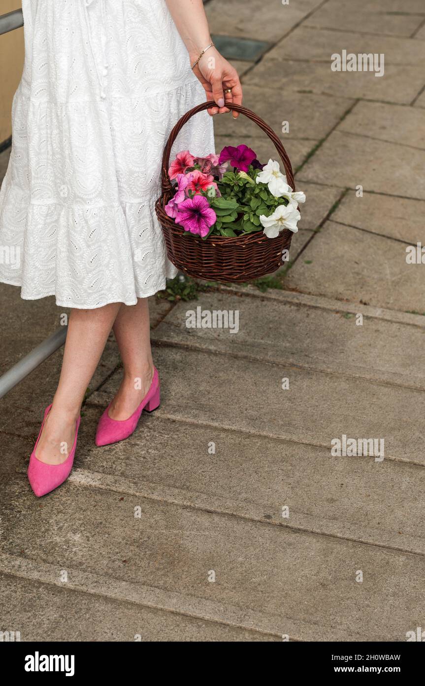 Basket in hands and feet in shoes. Stock Photo