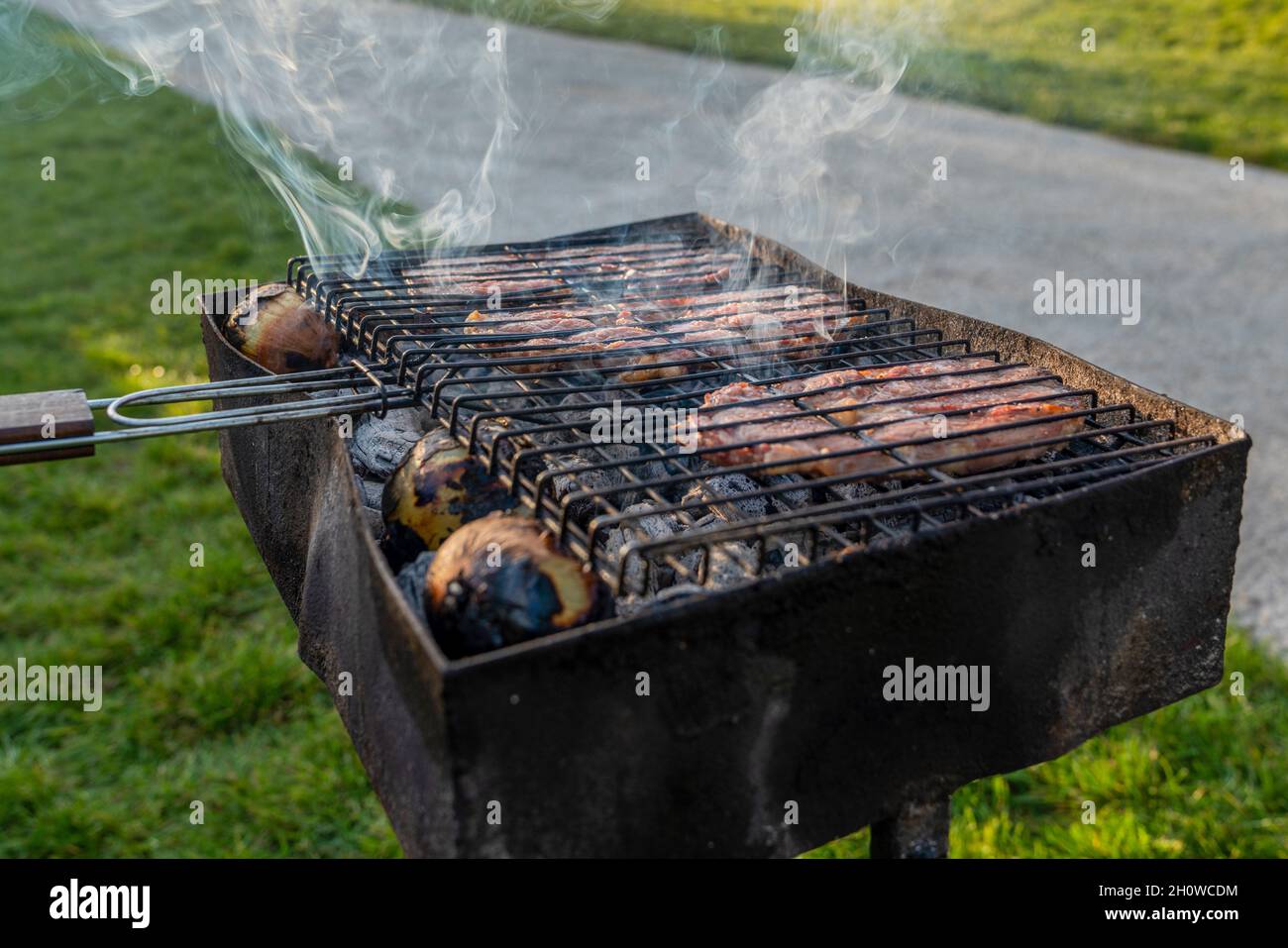 Beef rib steak cooking on black dirty barbecue. Stock Photo