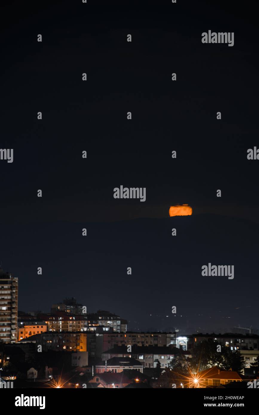 Vertical shot of a modern illuminated cityscape under the night sky ...