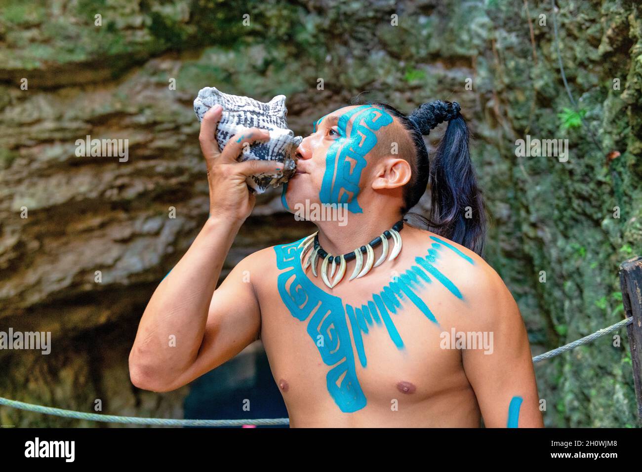 Body paint in Mayan man who is blowing a seashell, Mexico, 2021 Stock Photo
