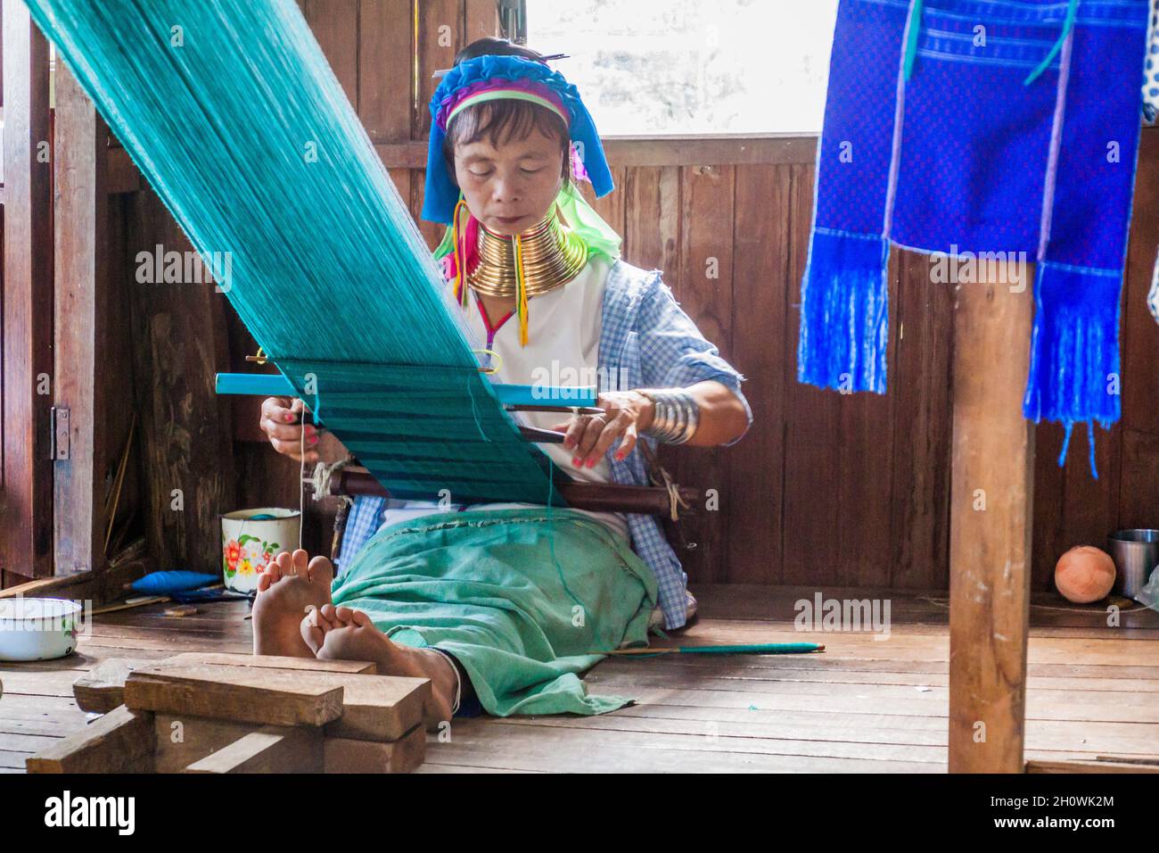 INLE, MYANMAR - NOVEMBER 28, 2016: Kayan long neck woman working in a fabric workshop at Inle lake, Myanmar Stock Photo