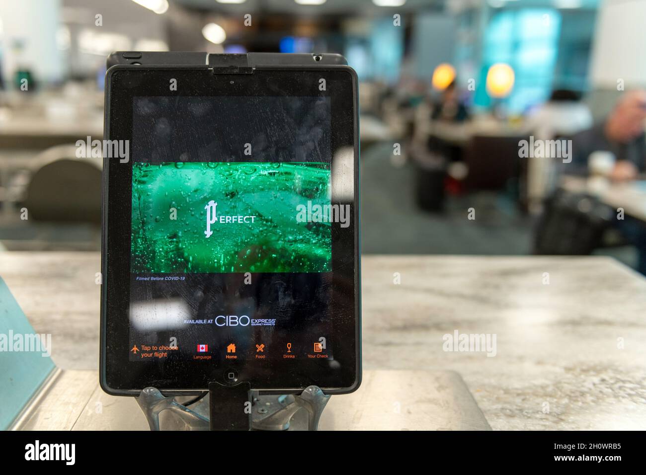 Tablet with a Perrier water advertisement on a restaurant table in Pearson International Airport in Toronto city, Canada, Year 2021 Stock Photo