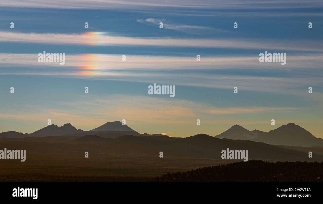 A parhelion, commonly known as a “sun dog” directly over the top of the 3 Sisters in Deschutes National Forest.  Shot from Pilot Butte in Bend Oregon. Stock Photo