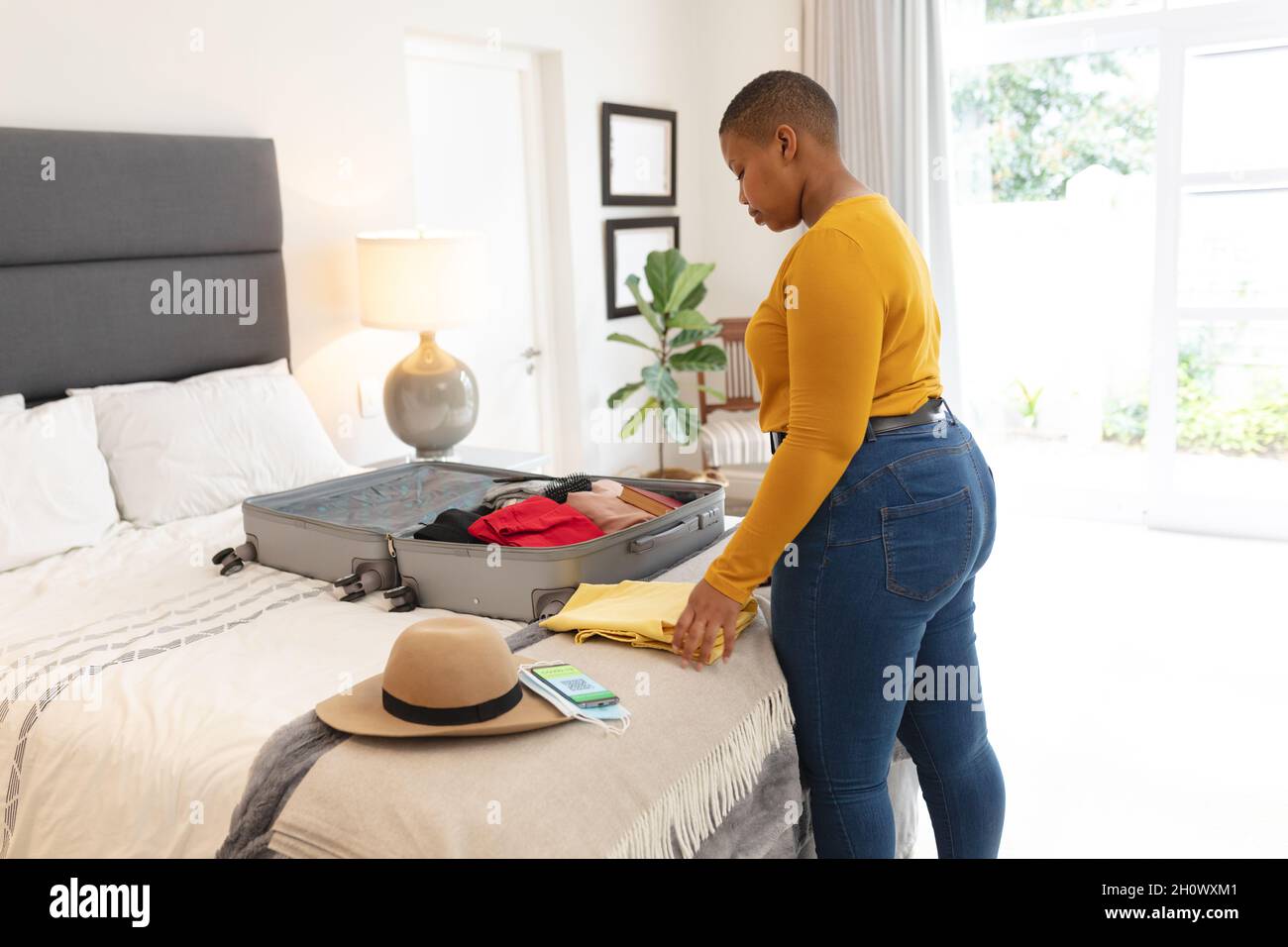 African american plus size woman packing suitcase for travel Stock Photo