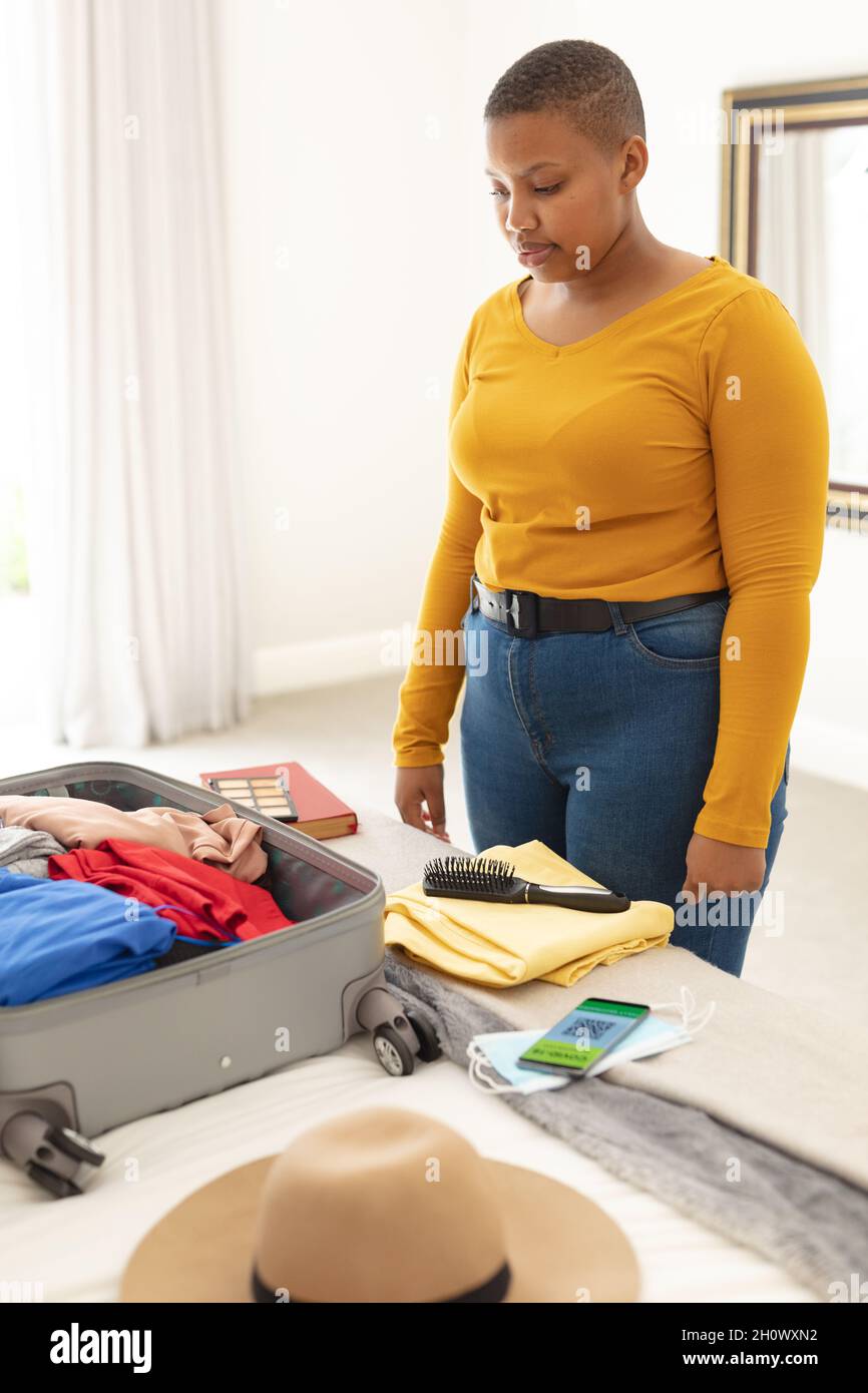 African american plus size woman packing suitcase for travel Stock