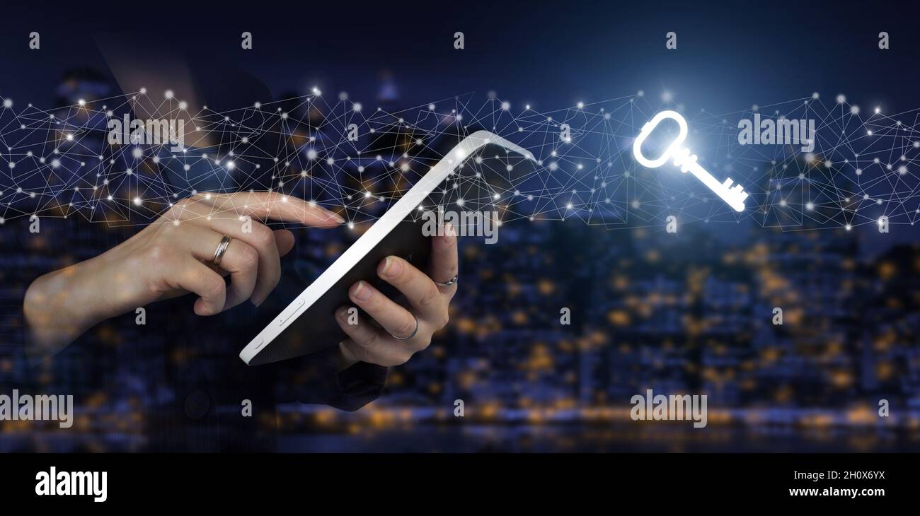 Safety and security concept. Hand touch white tablet with digital hologram sign on city dark blurred background. Key Keyword Icon Business Internet Te Stock Photo