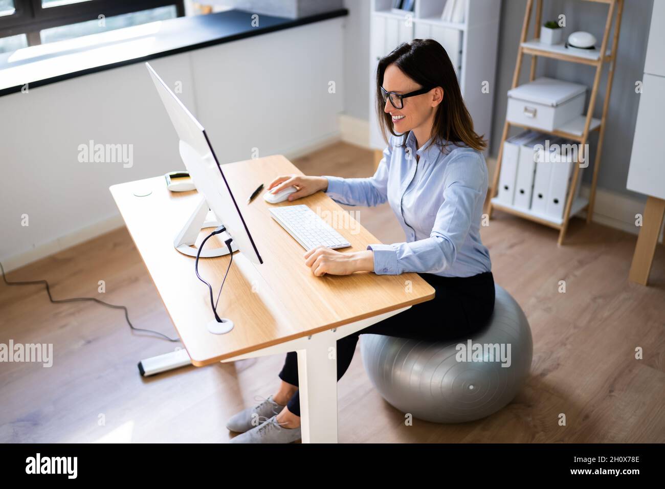 Correct Posture At Desk In Office Using Fitness Ball Stock Photo Alamy