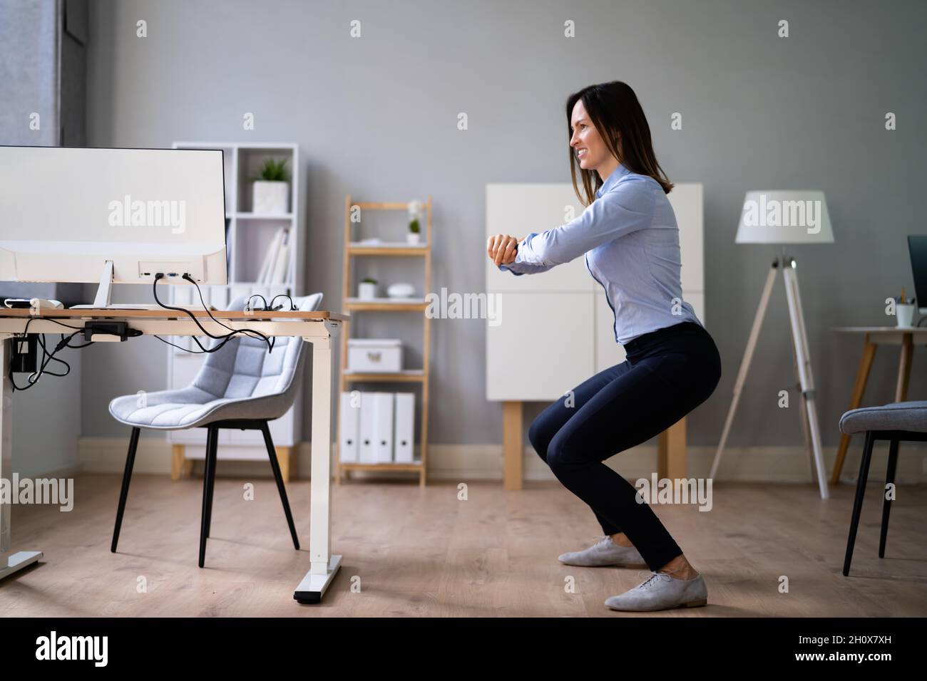Workplace Sit Up Exercise At Office Desk Stock Photo
