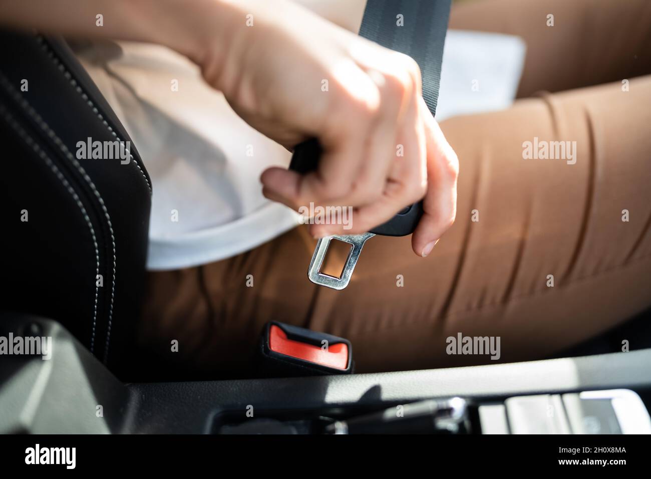 Closeup Of Woman Fastening Seat Belt In Car Stock Photo