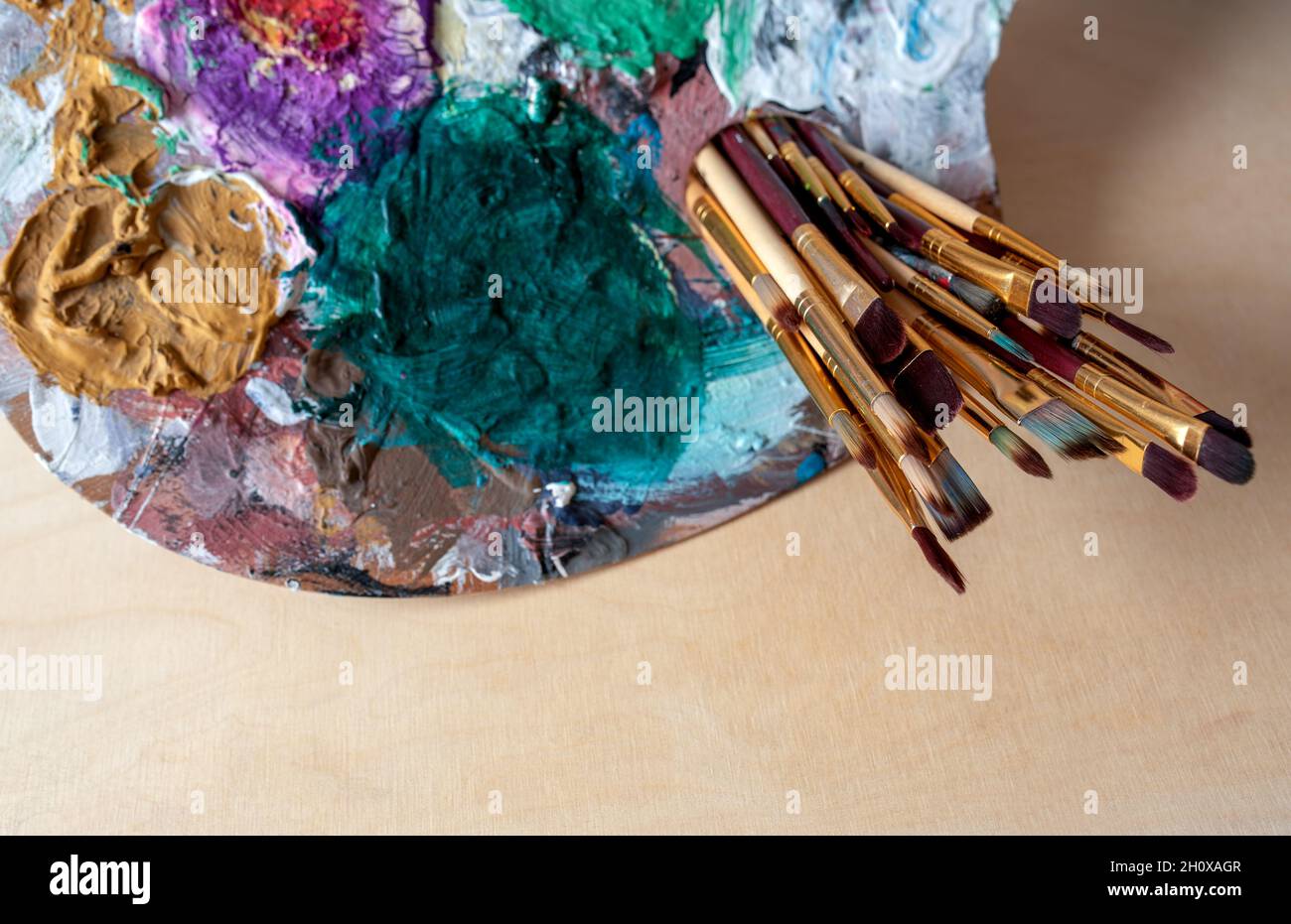 artist's palette with brushes over a wooden background Stock Photo