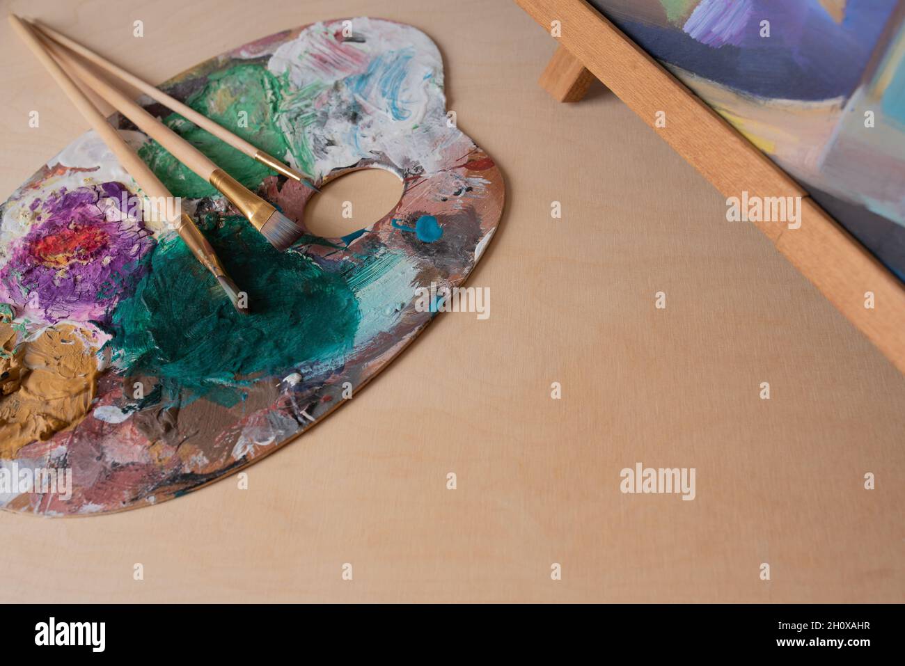 artist's palette and brushes over a wooden background Stock Photo