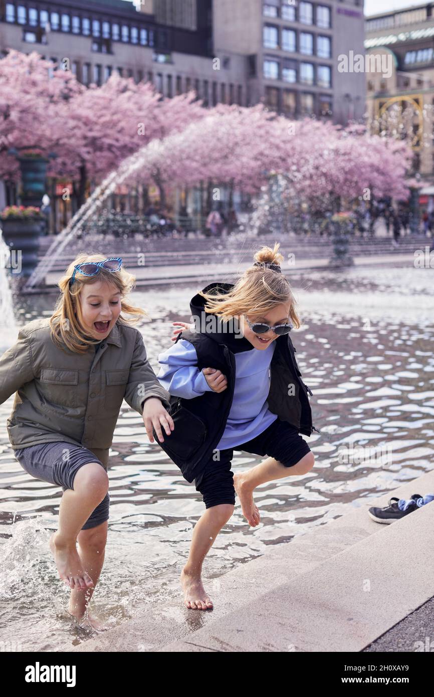 Girls playing in fountain Stock Photo - Alamy