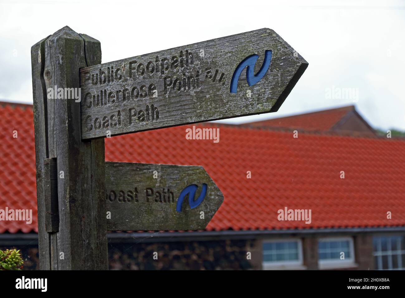 Wooden signpost showing Coast Path, Craster Stock Photo