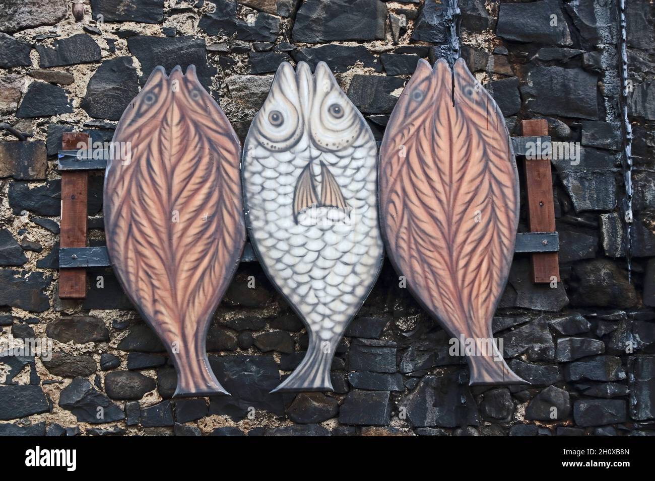 Sign depicting 3 kippers outside smokehouse, Craster Stock Photo