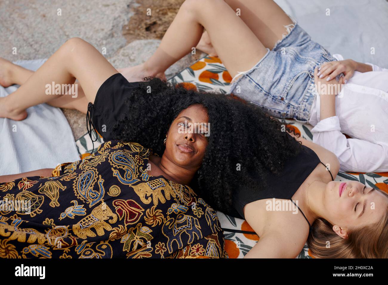 Three friends lying on blanket Stock Photo