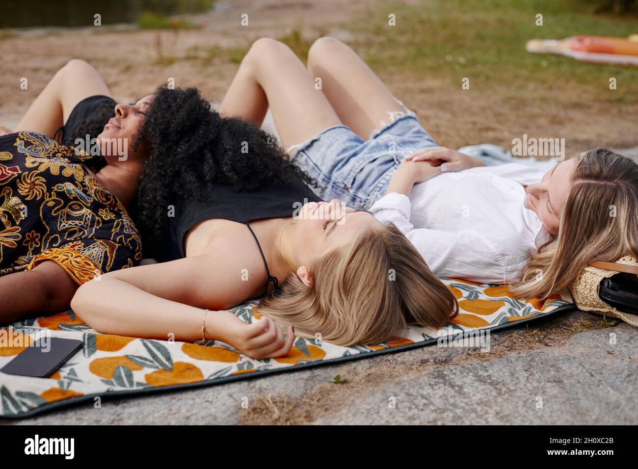 Three friends lying on blanket Stock Photo