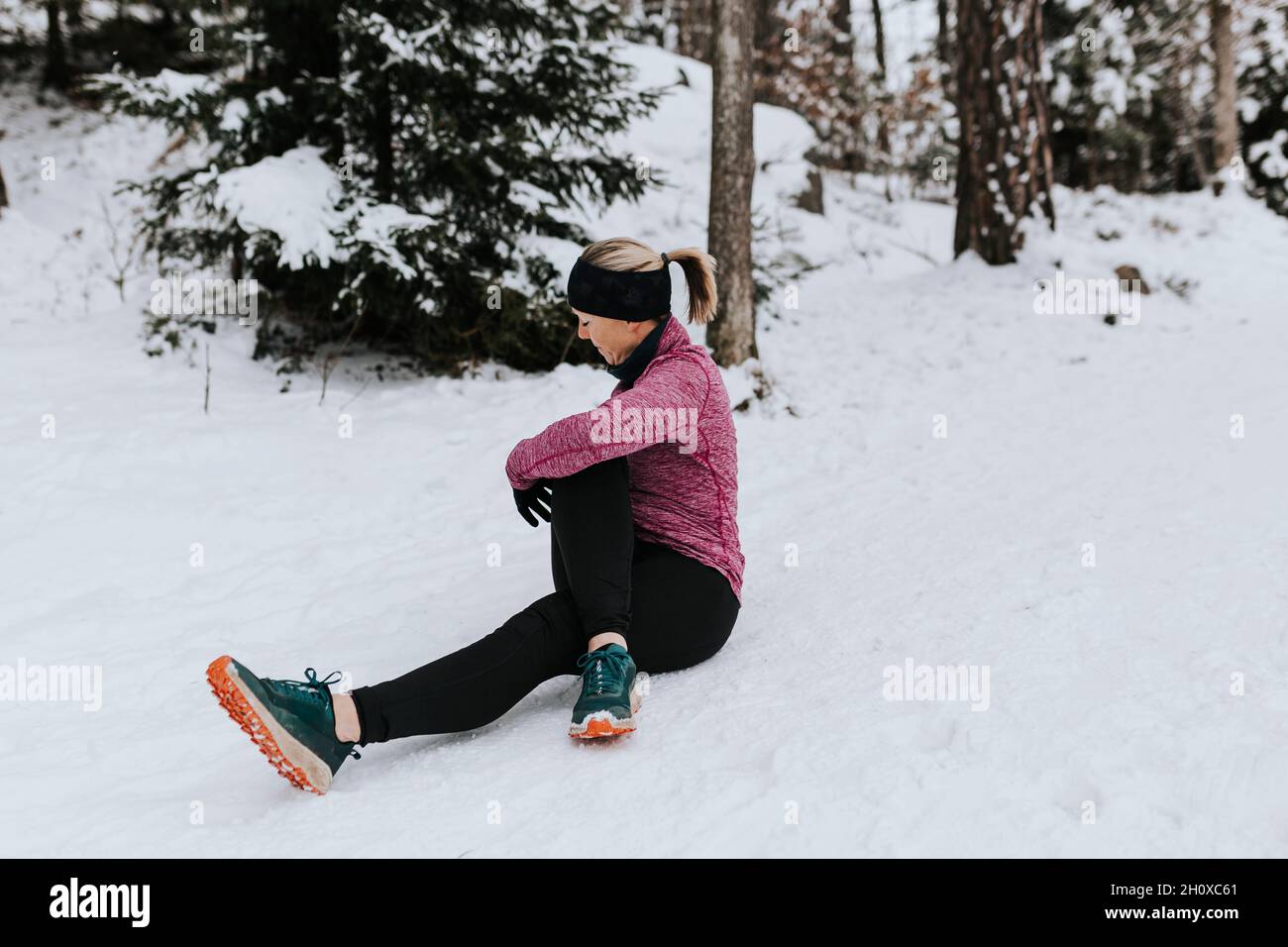 Woman stretching in winter forest Stock Photo