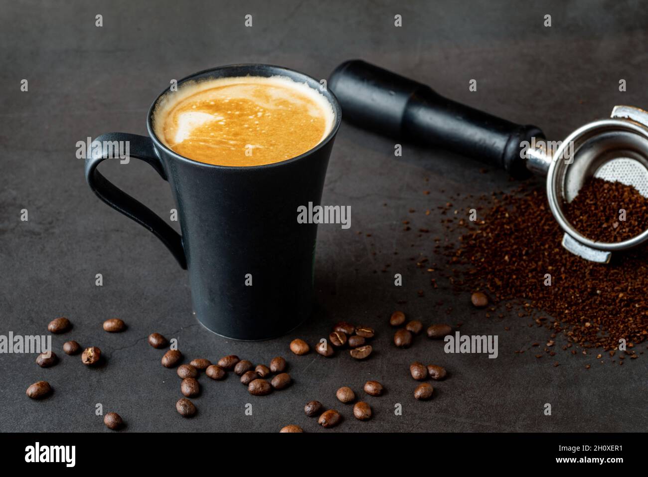 Relaxing latte coffee in black porcelain cup on stone table Stock Photo