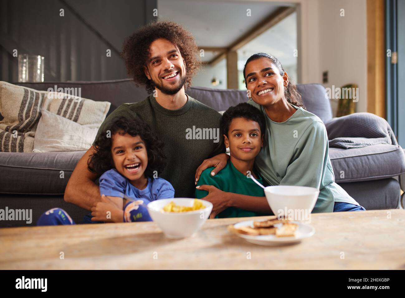 Family eating breakfast in living room Stock Photo