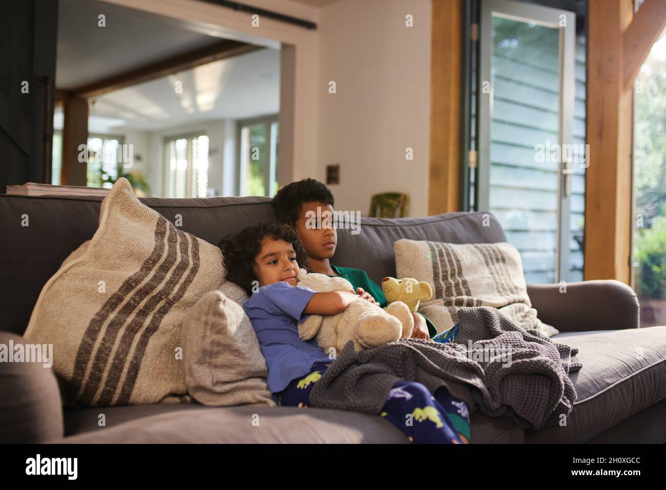 Two boys watching TV on sofa Stock Photo