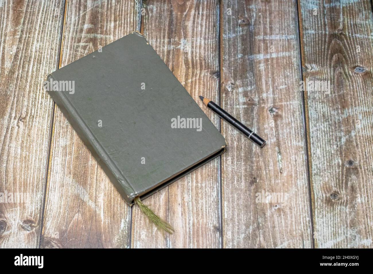 old heavily used closed sketchbook and pencil on a worn brown colored  wooden surface Stock Photo - Alamy