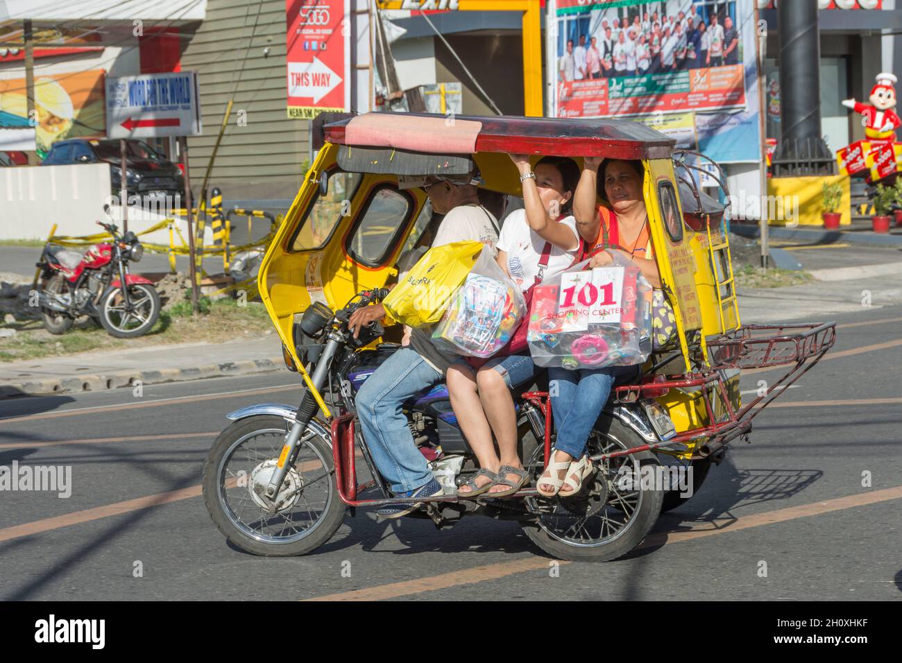 Typical Filipino motor taxi with passengers in the streets of Naga city ...