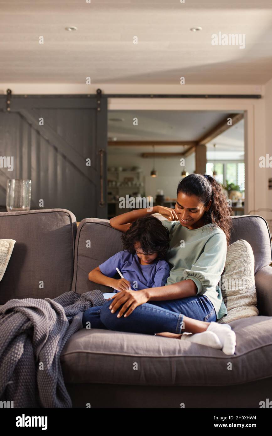 Mother and son using tablet on sofa Stock Photo