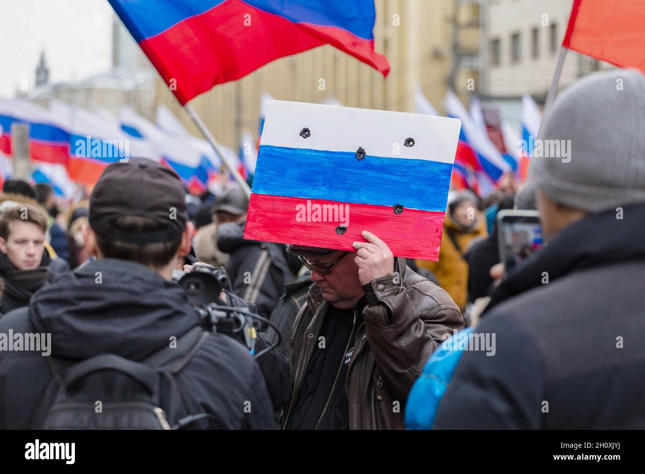 Moscow, Russia. 24th Feb, 2019. A demonstrator with a pretend shot through Russian flag seen during the march.Thousands of people marched in Moscow in memory of opposition leader Boris Nemtsov, who was murdered on 27 February 2015. In addition to the traditional liberal activists for this action, the march was attended by libertarians, nationalists and the movement 'Decommunization' of Dmitry Enteo. (Photo by Mihail Siergiejevicz/SOPA Imag/Sipa USA) Credit: Sipa USA/Alamy Live News Stock Photo