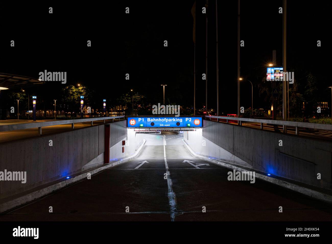 Underground car park entrance with german inscriptions in Luzern. Night view, illuminated by lights. Street signs on the ground. Nobody inside Stock Photo