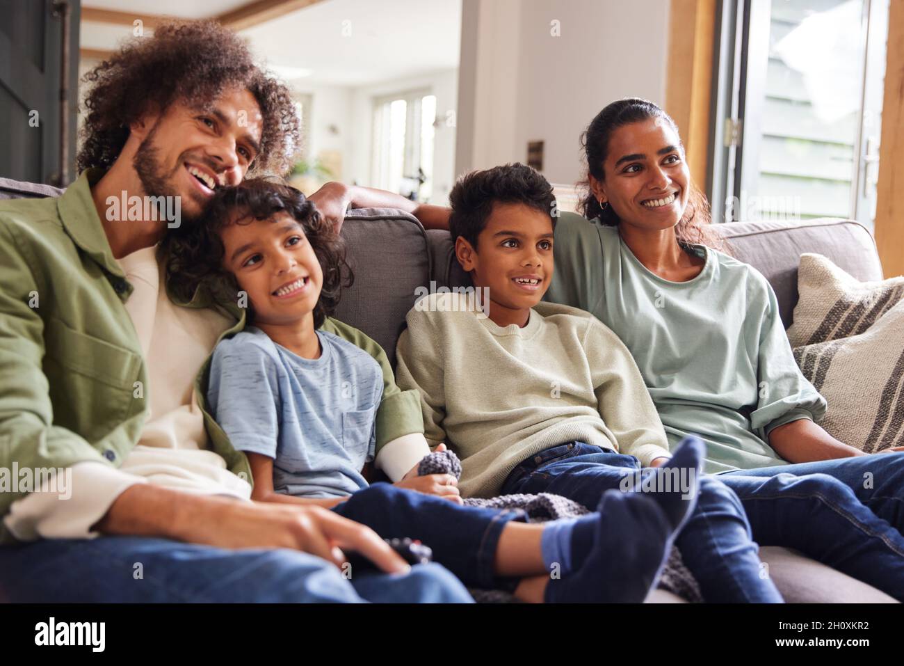 Family watching TV at home on sofa Stock Photo