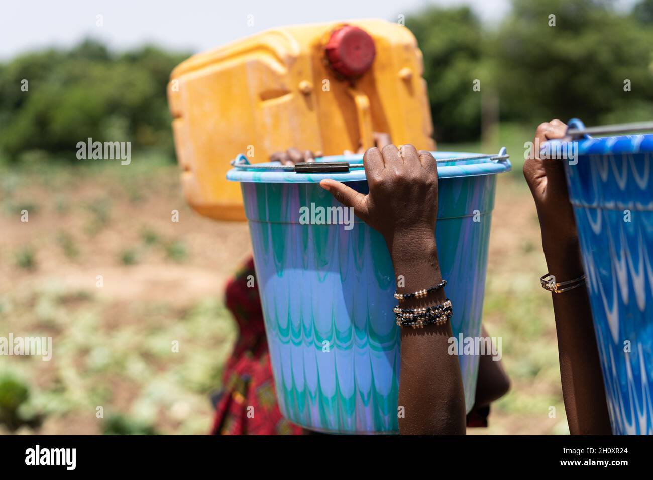 Close up of colorful water containers carried by some black African ...