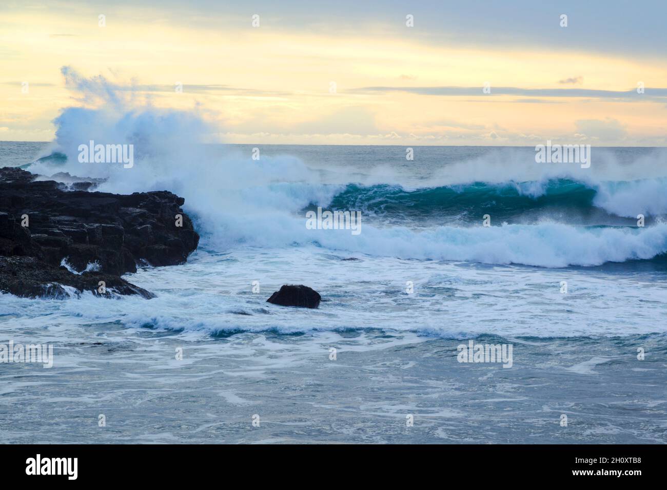Energetic waves crashing against volcanic rocks at dusk at Londranagar on the Snæfellsnesnes peninsula in the Western part of Iceland Stock Photo