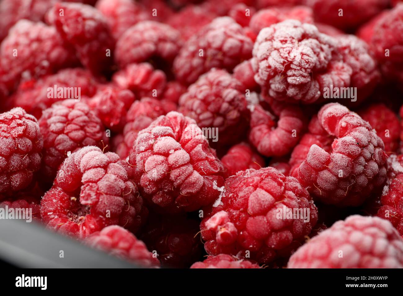 Frozen Raspberry Colour Frozen red raspberry all over background,close up Stock Photo - Alamy