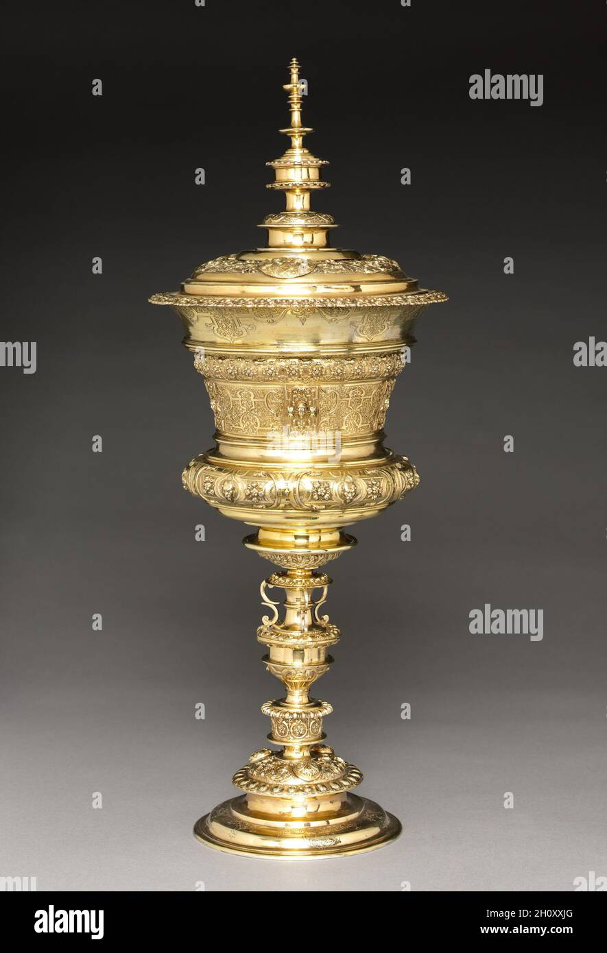 Standing Cup, mid-late 1500s. After a design by Virgilius Solis (German, 1514-1562). Gilt silver; overall: 50.8 x 20.4 cm (20 x 8 1/16 in.).  Large ceremonial silver cups with covers were a status symbol in the late 16th century, particularly when gilded like this superb example from Nuremberg. Stylish and grand, these cups provided the ultimate vessel from which a royal guest or aristocratic visitor could drink at a formal banquet. They came to be known as willkom, or welcome cups, as a result. The lid, mid-section, and base are all cast in sections, creating imposing height and stability for Stock Photo