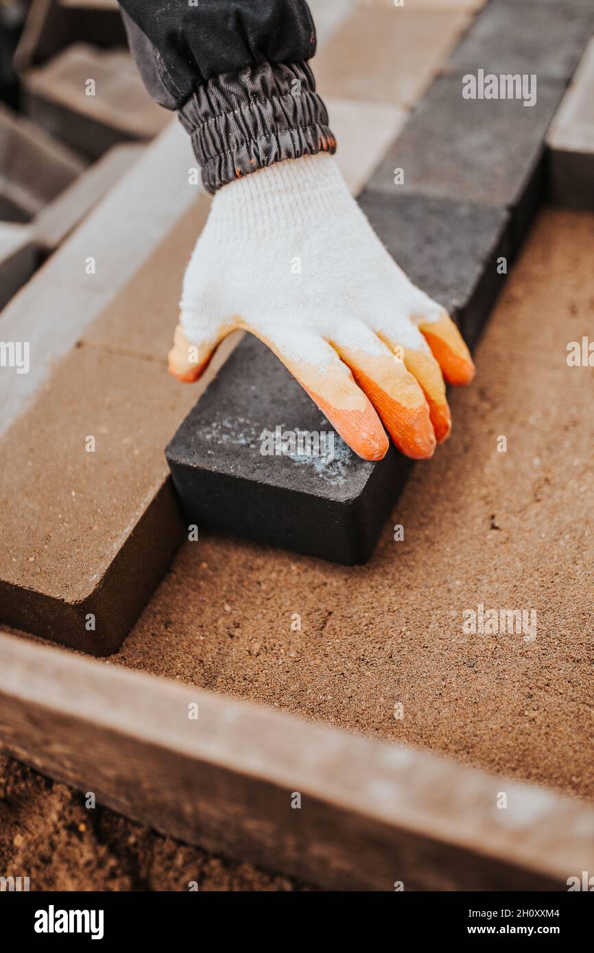 Laying paving slabs of different shades on a sand cushion combining