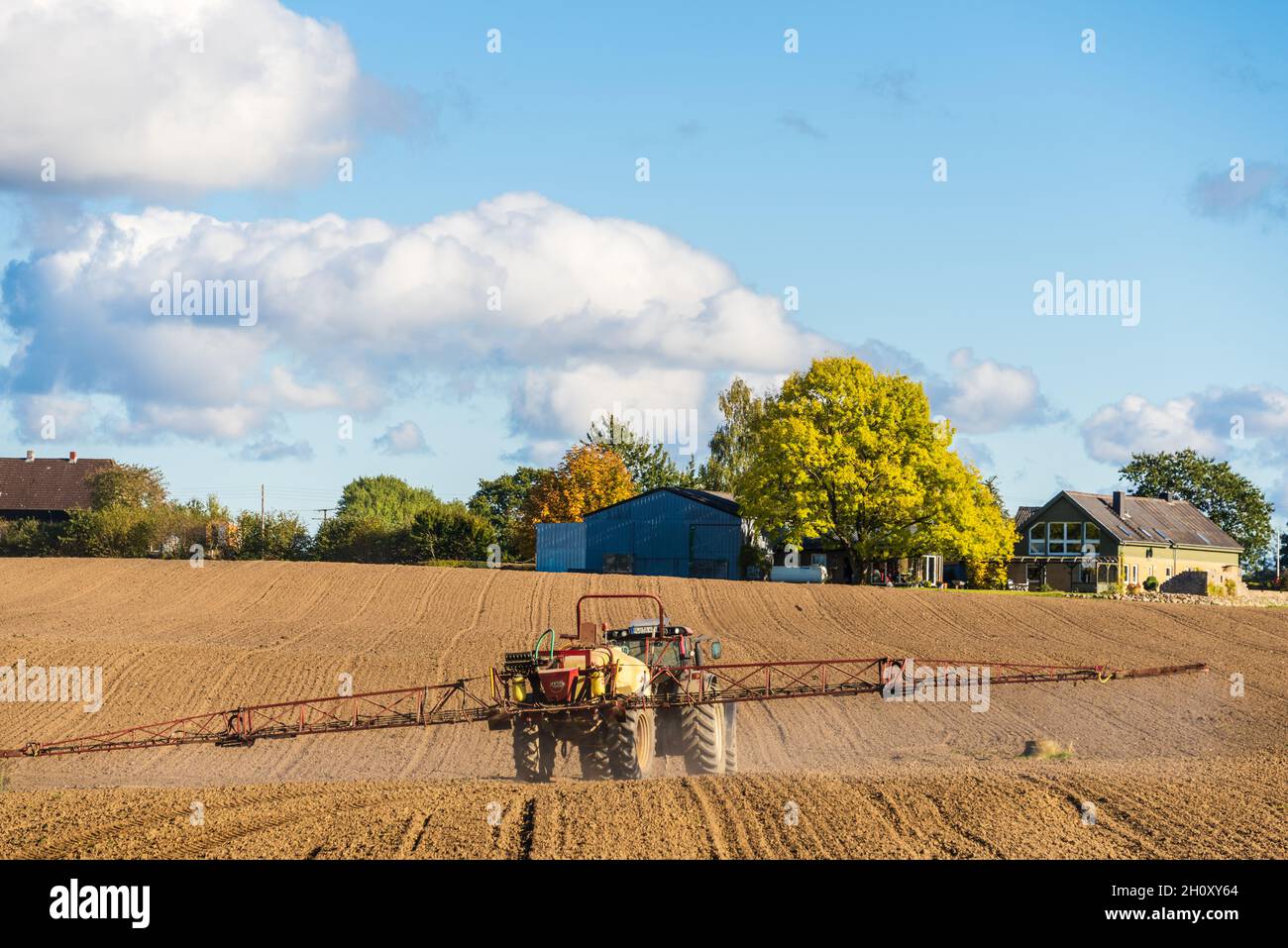 Ein Bauer mit Trecker bestellt sein  Feld im Herbst nach der Ernte Stock Photo
