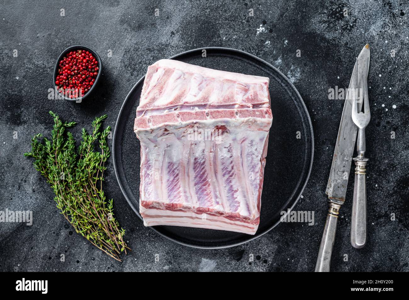 Fresh Raw whole rack of pork loin chops with ribs on a plate with meat