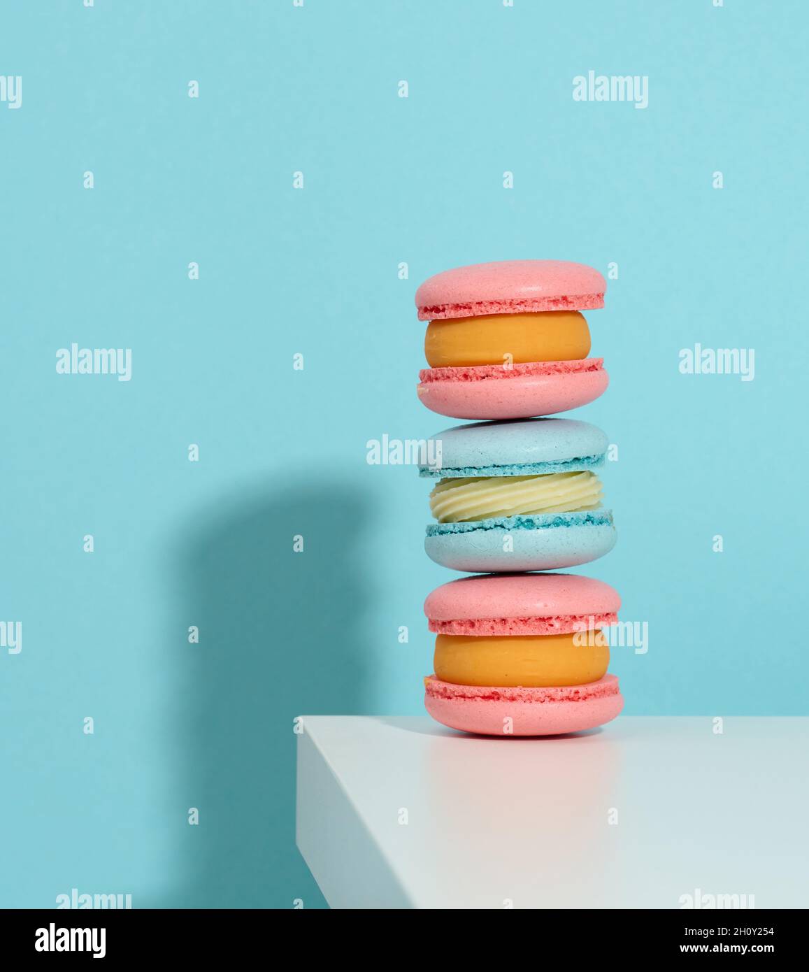 baked pinke round macarons on a blue background, delicious dessert Stock Photo