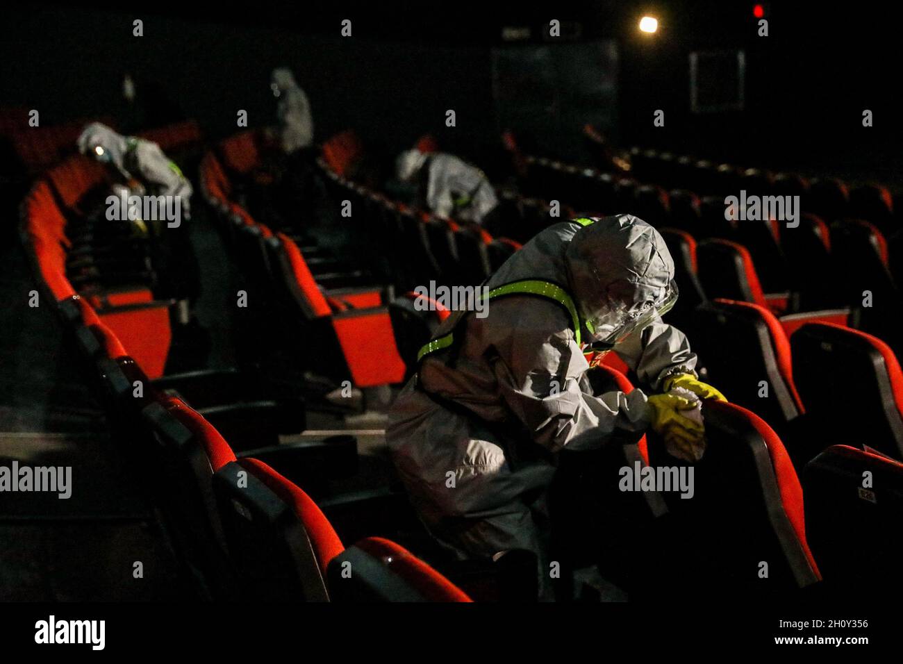 October 15, 2021 Workers wearing protective suits sanitize a movie