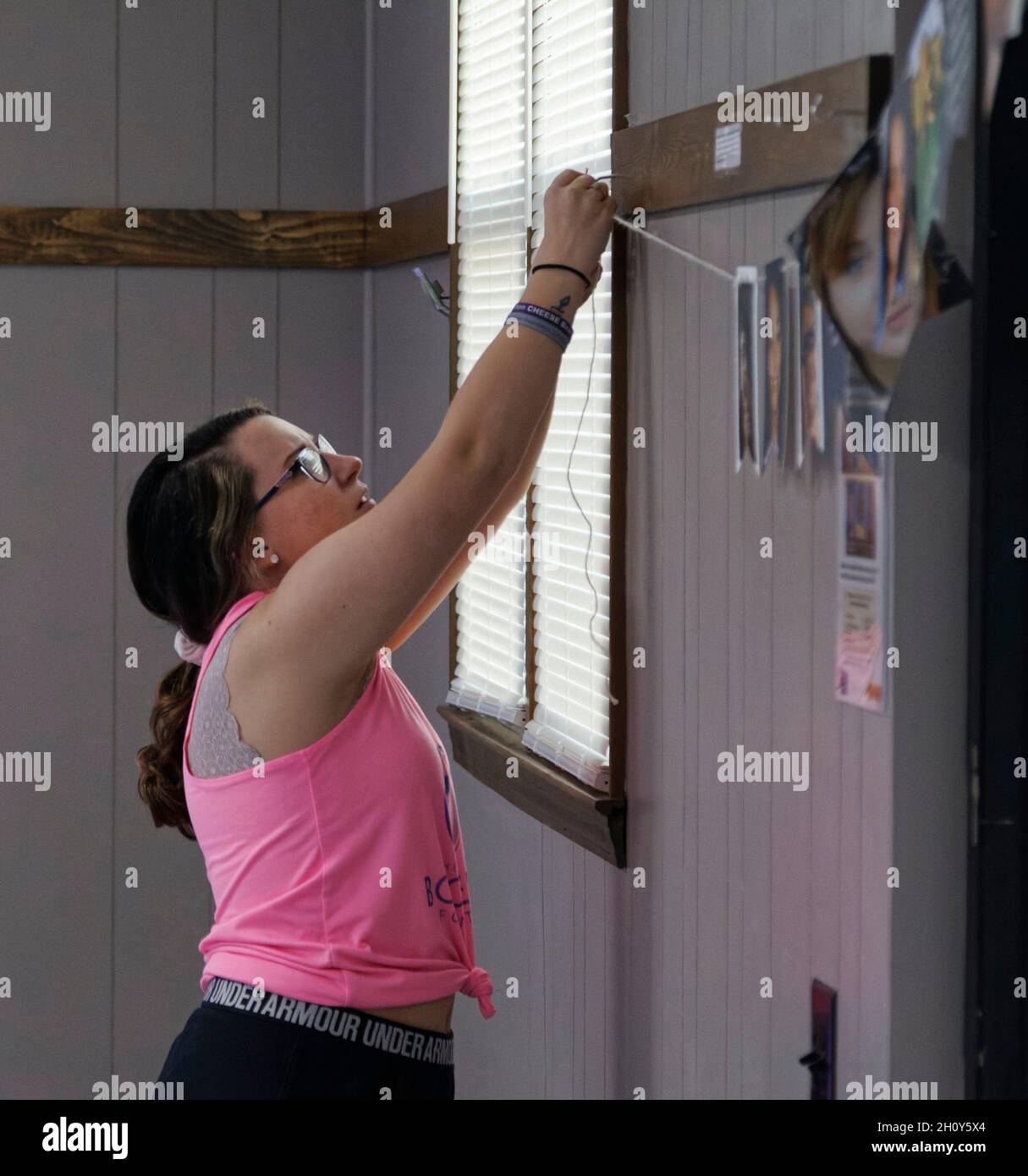 Macey Armstrong hangs photographs of victims who lost their lives to drug  addiction before "Our Community Fight: Remembering Our Loved Ones &  Honoring Their Legacy," a public forum hosted by the nonprofit