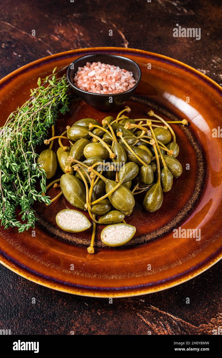 Marinated canned Capers berries in a rustic plate. Dark background. Top ...
