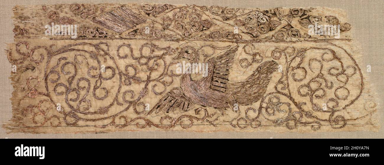 Embroidered fragment with bird among vines, 1100s. Iraq, Baghdad, Seljuq period. Plain weave: silk warp and cotton weft (mulham); embroidery, couched and split stitches: silk and metallic thread; overall: 7.3 x 21.6 cm (2 7/8 x 8 1/2 in.). Stock Photo