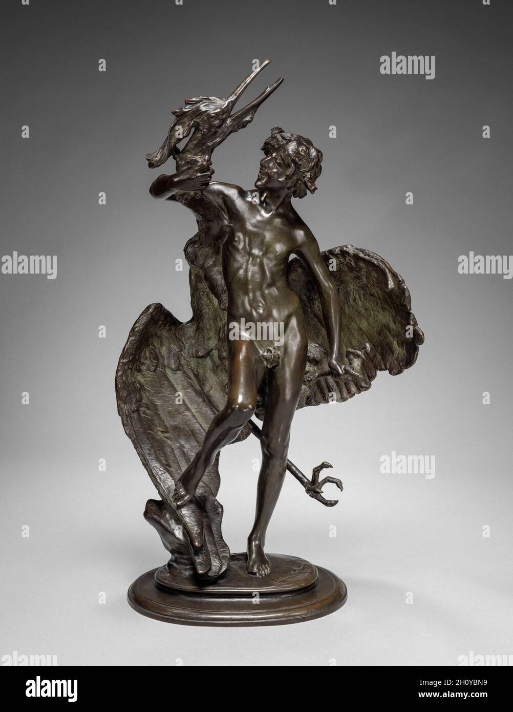 Young Faun with Heron, 1890. Frederick William MacMonnies (American, 1863-1937). Bronze; overall: 68.6 cm (27 in.).  MacMonnies originally created this composition as a large garden sculpture, but later marketed small-scale versions, such as this example, to adorn interior spaces. The subject presents a boyish mythological figure mischievously grasping a bird whose ample wings curve around him. A striking visual contrast is achieved through the variegated textures of the heron’s feathers and the faun’s smooth flesh. Stock Photo